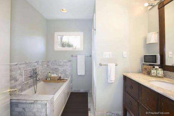 Master bathroom with a Jacuzzi bath tub, and steam shower.