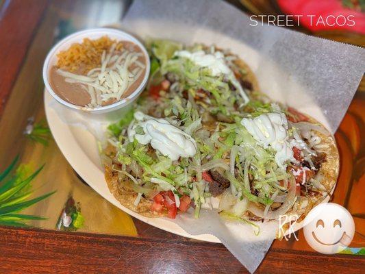 Lengua, shredded beef & carnitas tacos with upcharge for lettuce, tomatoes, sour cream & grilled onions (w/rice & beans)