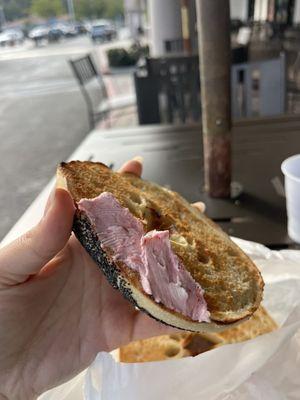 Delicious poppy seed bagel with strawberry cream cheese.