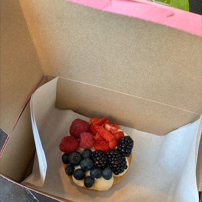 Packaged fruit pizza. Sugar cookie with frosting and berry toppings.