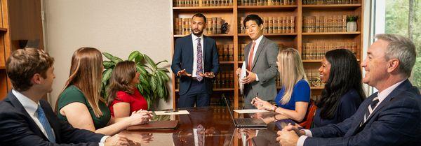 Several members of the Montlick Injury Attorneys Legal Team meet to discuss a client's case.