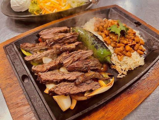 Skillet beef fajitas with herb rice, charro beans and all the fixings.