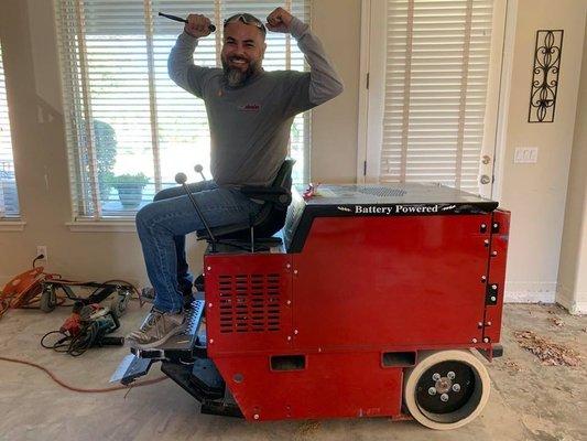 Our DustSharkz dust free tile removal expert Antonio riding our ride on floor scraper tool.