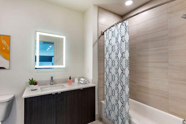 Spa inspired bathroom with lighted vanity mirrors at Lantower River Landing.