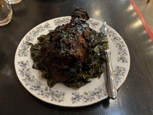 Lamb shank over greens.