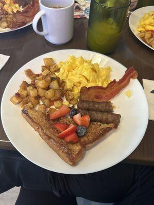 Potatoes, eggs , sausage , and French toast with berries