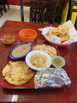 Cheese pupusa, pastor taco, beans, and rice with complimentary chips and salsa