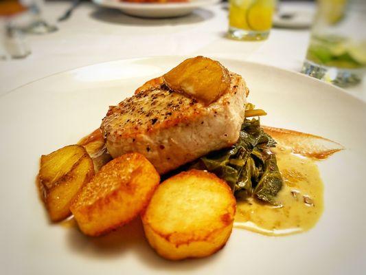 Pork loin with braised apples, collard greens and puffed potatoes.