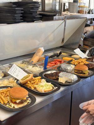 The entrees are lined up waiting to be topped off and served up hot.