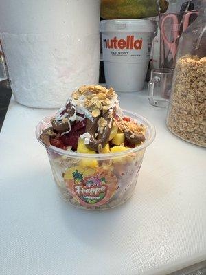 This is our açaí bowl top off with , Nutella,  granola, shredded coconut , strawberry& mangos