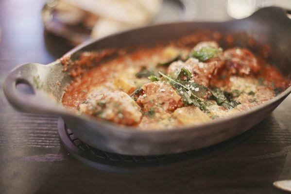 Wagyu Meatballs. Wagyu & pork meatballs in tomato sauce with polenta croutons, parmesan cheese, and topped with basil.