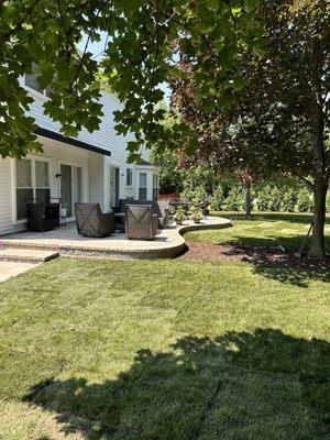 Patio with tree line and steps from sidewalk