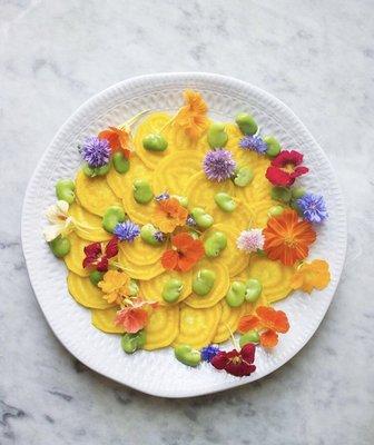 Golden beet salad with fava beans and edible flowers made by a Local Roots member with her Local Roots fresh vegetables.