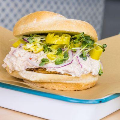 Tuna Salad Sandwich. tuna & giardiniera salad, radish sprouts, pepperoncini, red onion, crunchy house made potato chips on a potato roll.