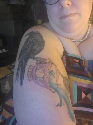 Raven and teacup upper arm tattoo.