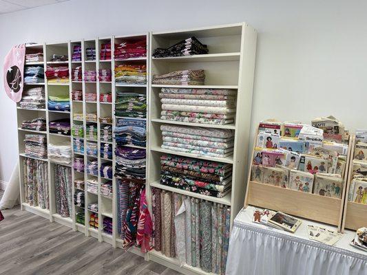 White wall unit shelves filled with folded fabric.