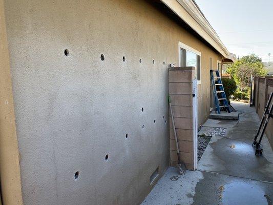 Holes drilled prior to the insulation being filled.