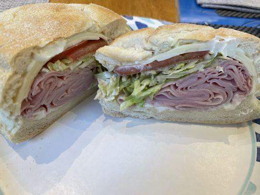 Ham and cheese on a roll with lettuce, tomatoes and mayonnaise