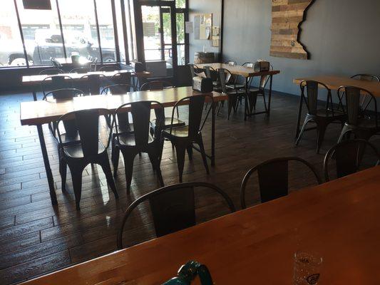 tap room w regular height tables & lots of light from windowed store front