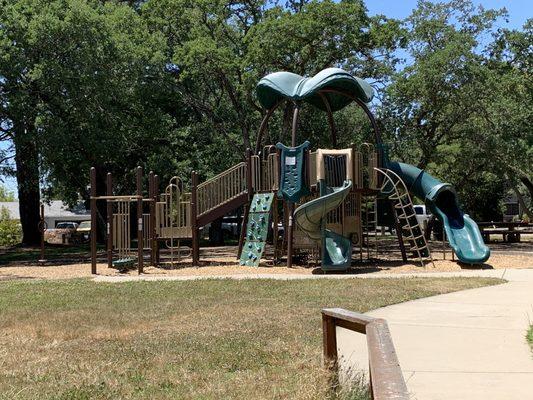 3 picnic tables, trash can, drinking fountain for people AND dogs. Hiking path leaving the park.