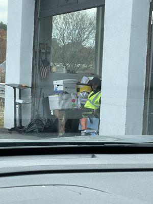 Employee sitting with his phone ignoring costumers driving in.