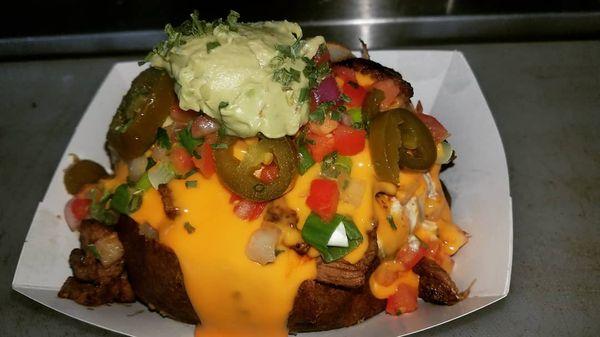 Our Popular Carne Asada SPUD. Topped with Butter, Sour Cream, fresh Pico de Gallo, green onions, jalapenos, Nacho Cheese and Guacamole.