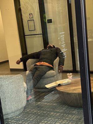 Another passed out person in a common area. This one is in front of the closed office.