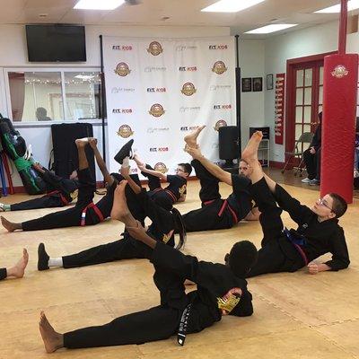 Martial arts kids stretching exercises in the Dojo.