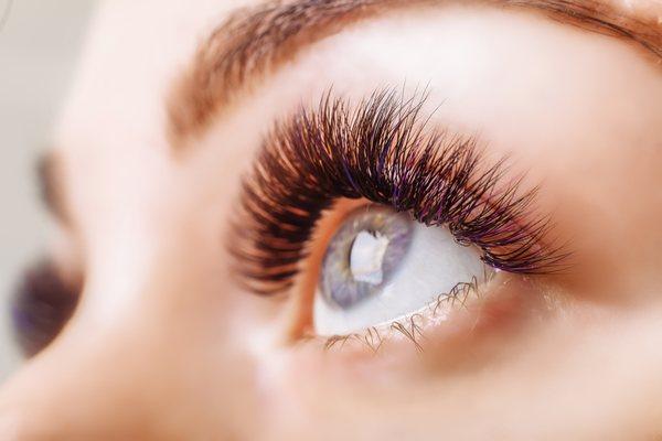 Eyelash extensions with purple and pink highlights.