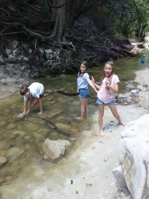 The kids having fun chasing small fish.