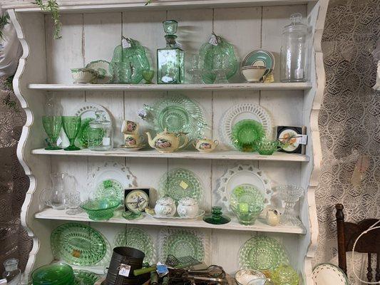 Display of antique green glass and other interesting items.