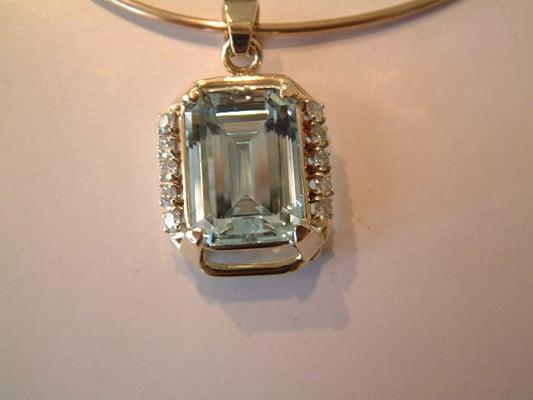 21 ct Emerald Cut Aquamarine set in 14K Gold with 10- .10 ct Round Brilliant cut Diamonds.