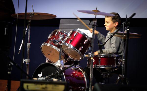 Already ready to play set, this young drummer is showcases his hard work at the recital.