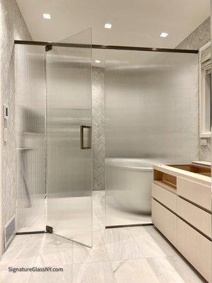 Shower enclosure we used 3/8" thick low-iron tempered reeded glass. Hardware in Brushed nickel finish.