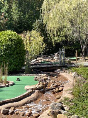 Putt putt river gently flowing under the wooden bridge from our glistening waterfall