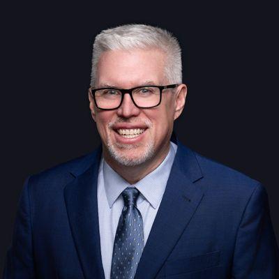 Headshot of CEO male in front of dark background