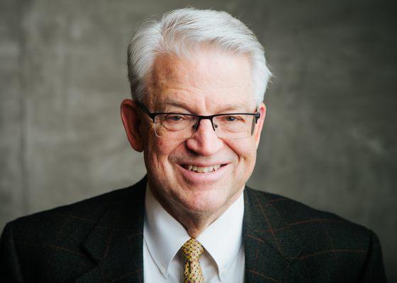 David Fraidenburg, CPA. Dressed in dark jacket, white shirt, and mustard colored necktie. Smiling and facing the camera.