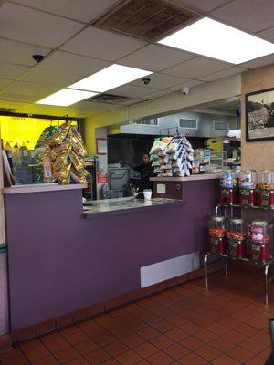 Counter with grill in back, not seen is side where they make pizzas