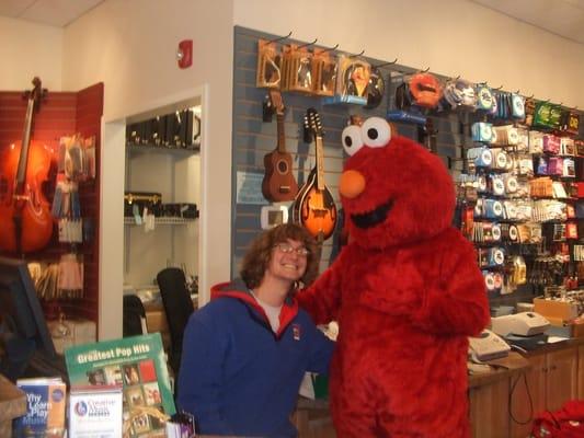 Elmo is a frequent visitor. Here he is with our strings teacher, Tucker Callander.