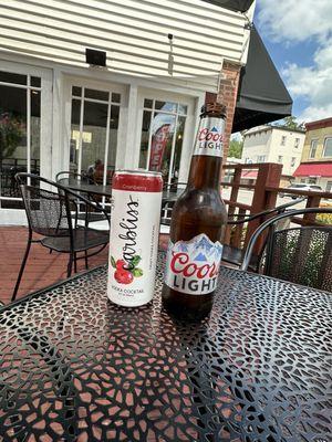 Canbliss cocktail in can and coors beer in bottle on table.