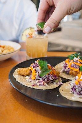 Ensenada Fish Tacos: beer-battered snapper, tomatillo salsa, chipotle aioli, cabbage lime slaw, queso fresco