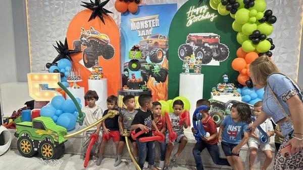 A group of kids holding balloons by a balloon decor