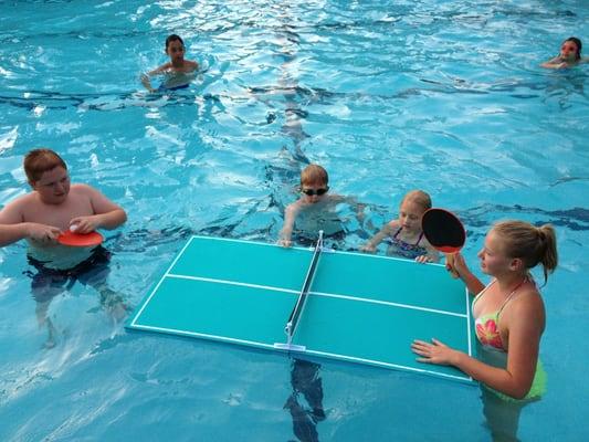 Kids having fun playing pool pong.