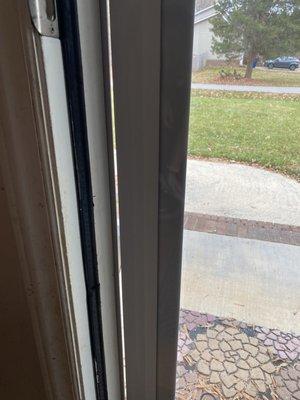 The storm door is locked and fully closed closed in this photo.