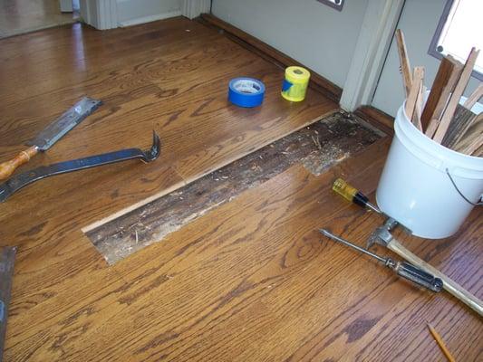 Before, broken and warped red oak floor.