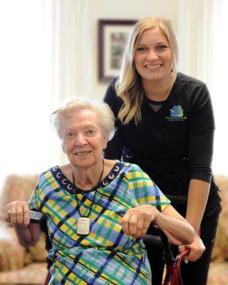 Friend of the Family Home Health Care Aide assisting senior in chair.