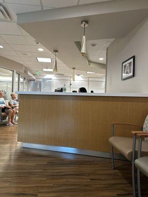 The view of the check-in desk from the back of the waiting area.