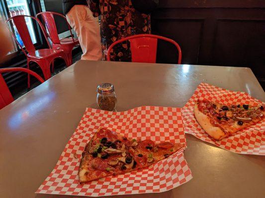 Supreme Pizza Slices and indoor seating