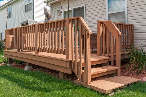 A deck refinished in light brown wood tone.