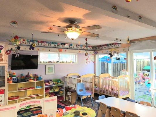 View from the main door. There are a few cribs for infants. There are lots of montessori style toys.